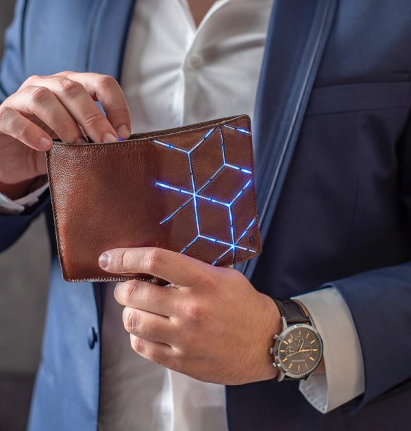 man in blue suit jacket holding brown leather wallet